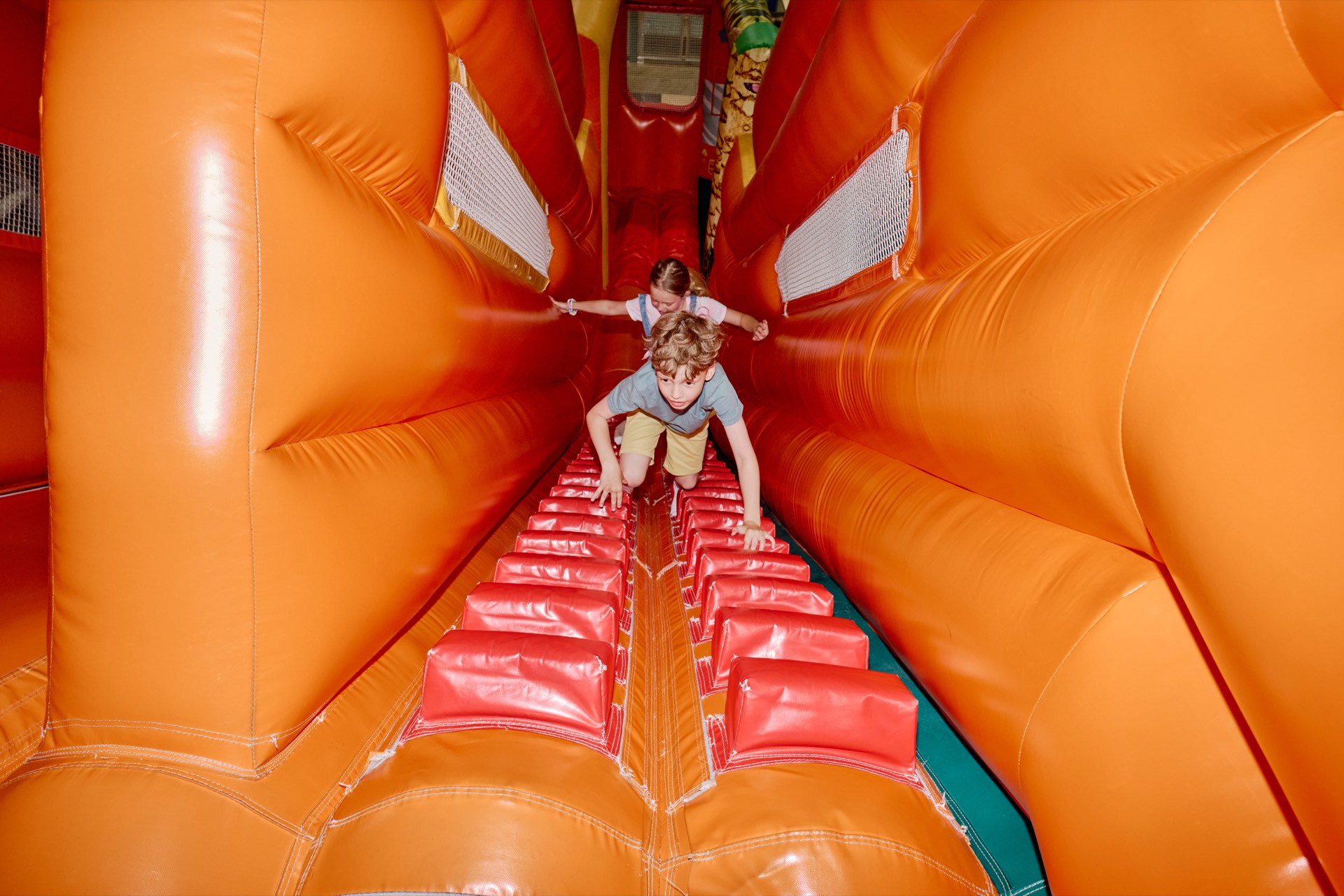 Niños trepando por un túnel hinchable